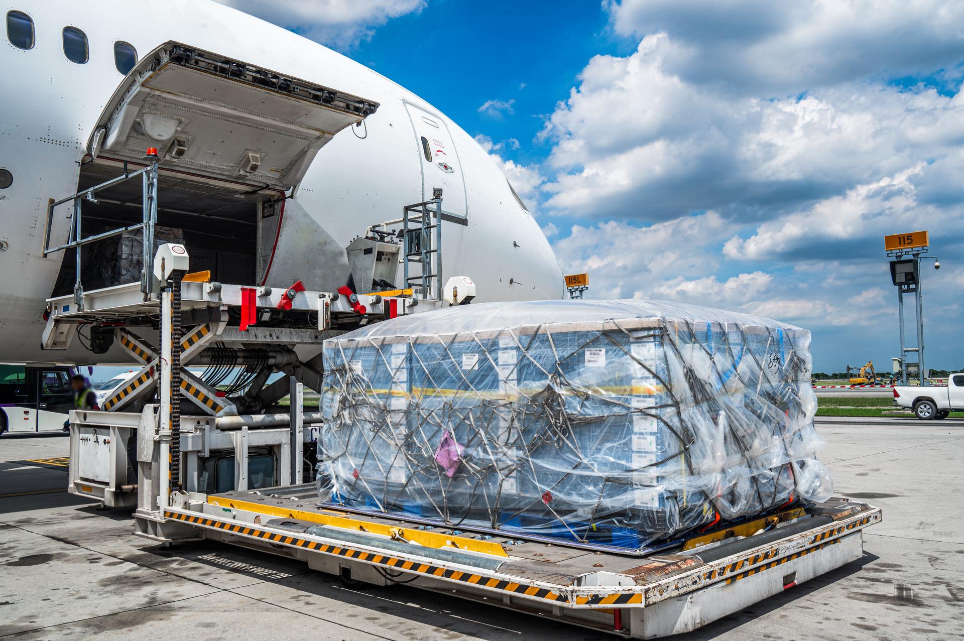 Air cargo logistic containers are loading to an airplane.