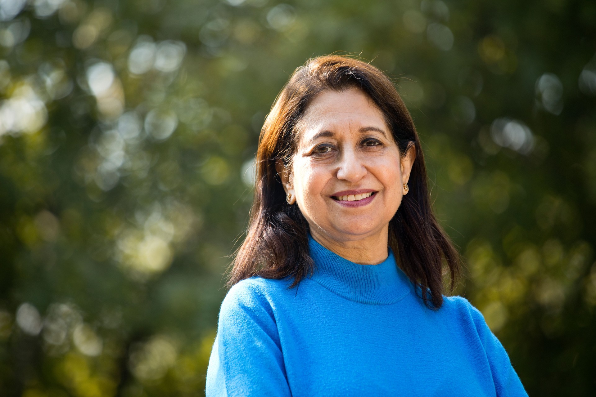Confident senior woman with arms crossed at park