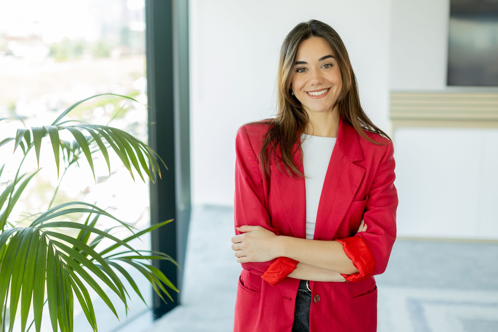 Confident woman smiling in bright office space during daytime