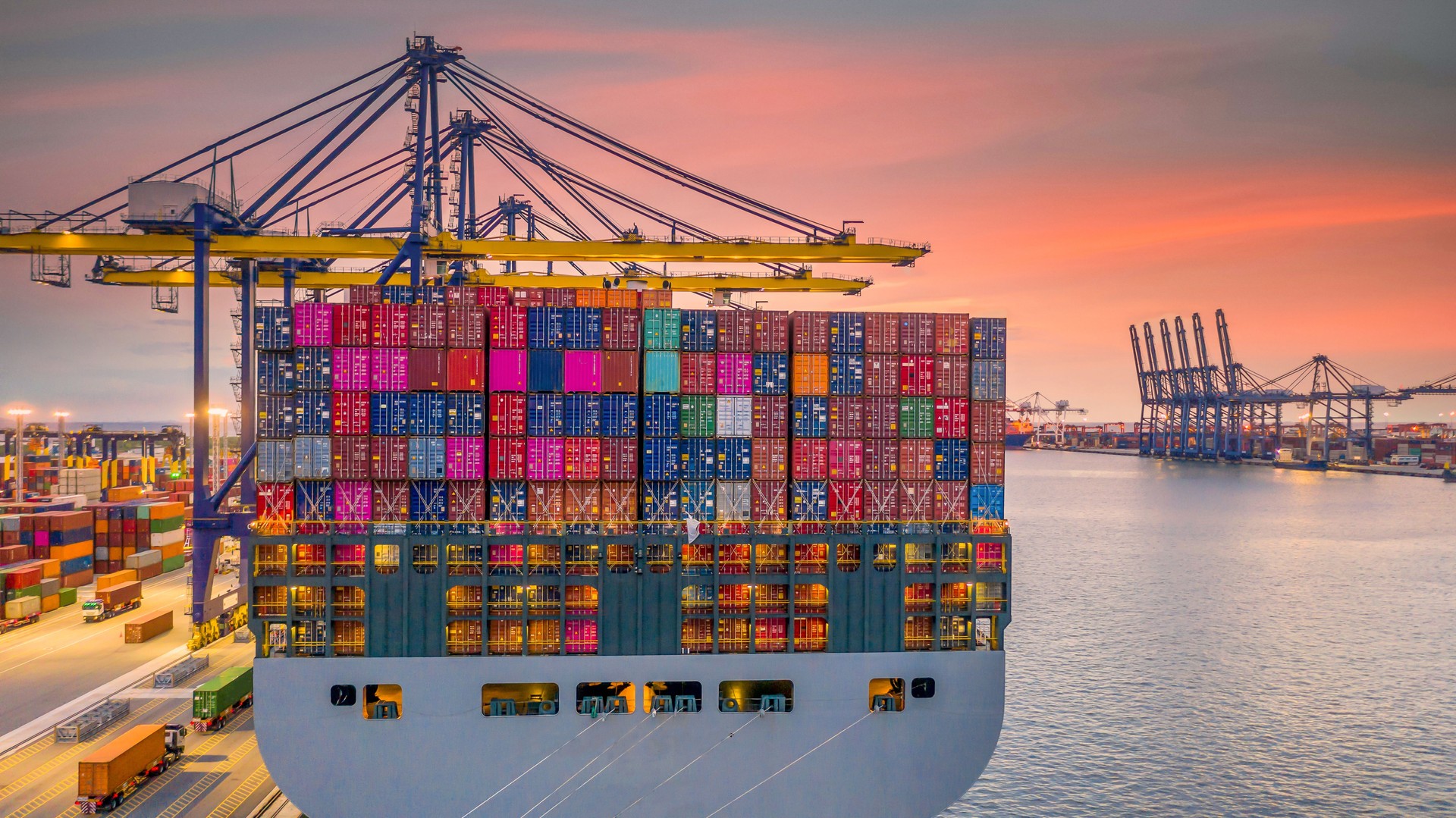 Container ship working at night, Business import export logistic and transportation of International by container ship in the open sea, Aerial view industrial crane loading cargo freight seaport.